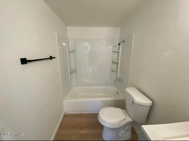 a white toilet sitting next to a bath tub