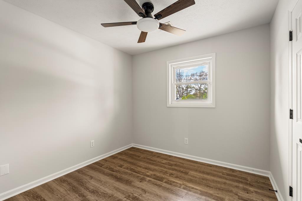 2312 Burnside Drive Columbus, GA 31907 - Photo 14 of 25 an empty room with wooden floor and ceiling fan