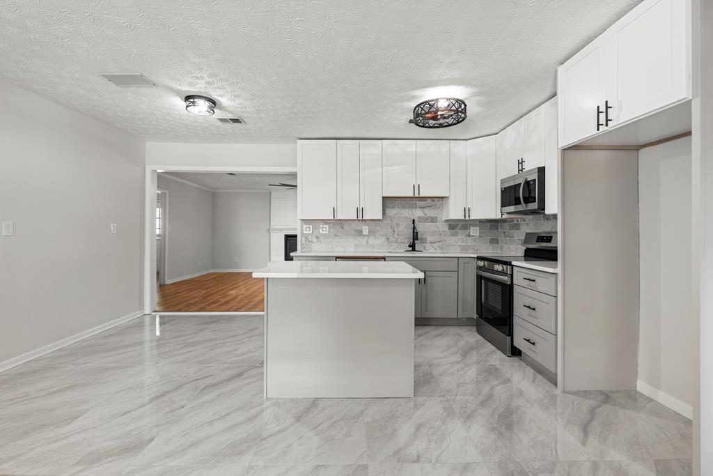 2312 Burnside Drive Columbus, GA 31907 - Photo 6 of 25 a kitchen with white cabinets and stainless steel appliances