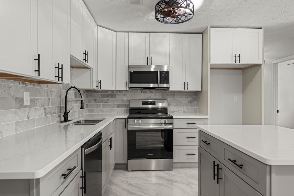 2312 Burnside Drive Columbus, GA 31907 - Photo 8 of 25 a kitchen with a sink stove and cabinets