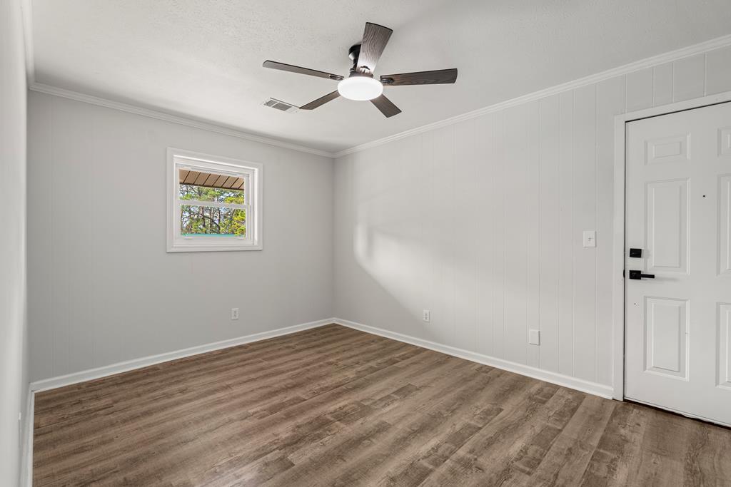 2312 Burnside Drive Columbus, GA 31907 - Photo 10 of 25 an empty room with wooden floor and ceiling fan