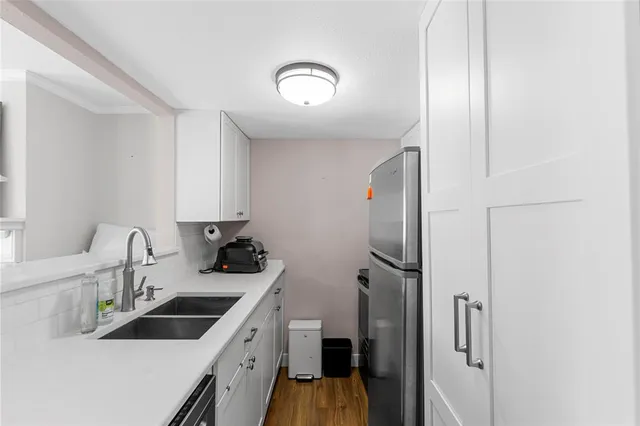 a kitchen with a sink and a stove top oven with wooden floor