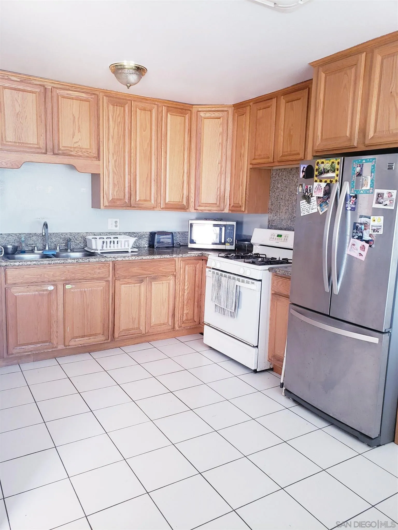 1704 Rees Road San Marcos, CA 92069 - Photo 2 of 6 a kitchen with stainless steel appliances granite countertop a refrigerator sink and cabinets
