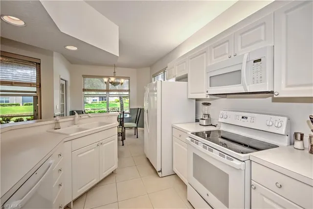 a kitchen with white cabinets and white appliances