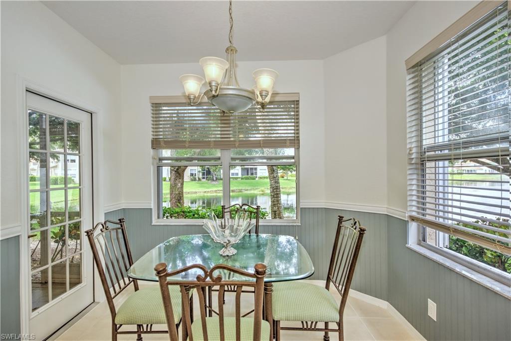 343 Dover Place, Unit A104 Naples, FL 34104 - Photo 16 of 36 a view of a dining room with furniture a chandelier and wooden floor