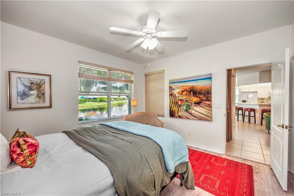 343 Dover Place, Unit A104 Naples, FL 34104 - Photo 22 of 36 a bedroom with a bed and a chandelier