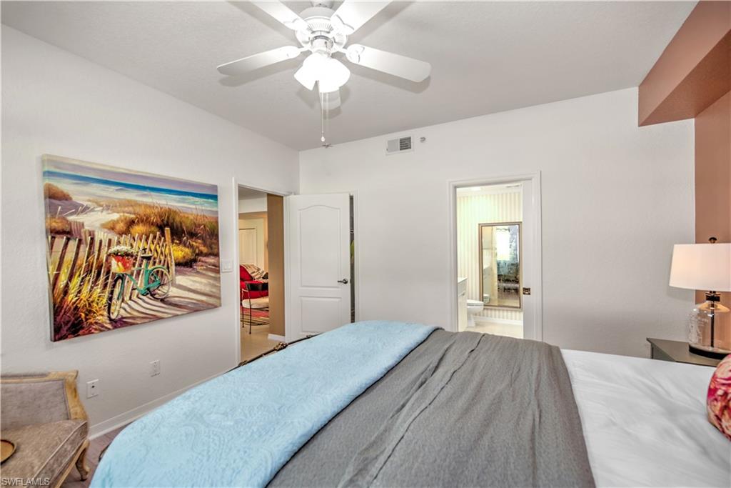 343 Dover Place, Unit A104 Naples, FL 34104 - Photo 23 of 36 a bedroom with furniture and a chandelier