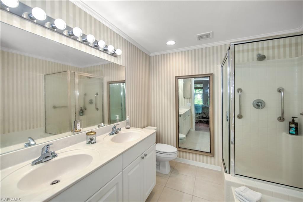 343 Dover Place, Unit A104 Naples, FL 34104 - Photo 24 of 36 a spacious bathroom with a double vanity sink mirror and shower