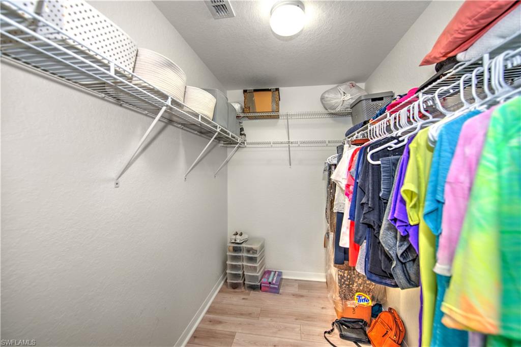 343 Dover Place, Unit A104 Naples, FL 34104 - Photo 25 of 36 a view of walk in closet with clothes