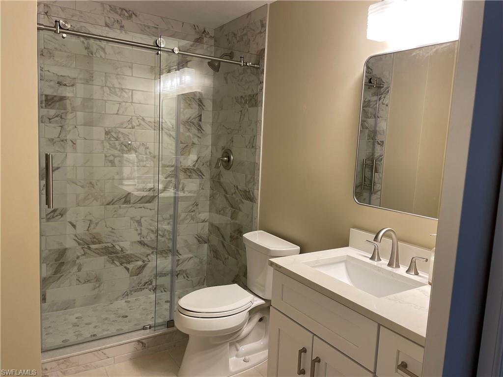 343 Dover Place, Unit A104 Naples, FL 34104 - Photo 29 of 36 a bathroom with a sink toilet and shower