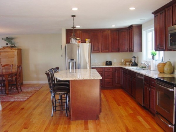 14 Carlson's Way Rutland, MA 01543 - Photo 5 of 20 a kitchen with stainless steel appliances wooden floors wooden cabinets a dining table and chairs