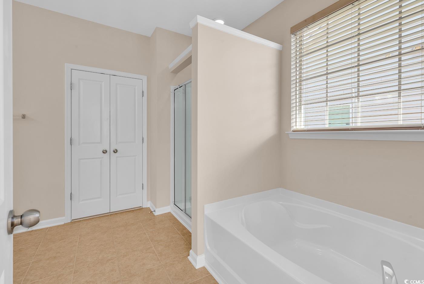 1612 Fairforest Court Conway, SC 29526 - Photo 23 of 40 Bathroom featuring a garden tub, a stall shower, light tile patterned floors, and a closet
