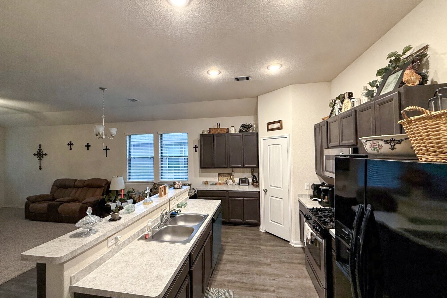 13979 Katlin Road Conroe, TX 77306 - Photo 2 of 13 a kitchen with stainless steel appliances kitchen island granite countertop a refrigerator a stove and a sink with wooden floor