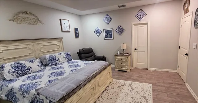 a bedroom with a bed and a lamp on dresser
