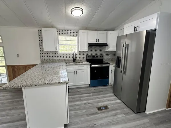a kitchen with a sink a stove and cabinets