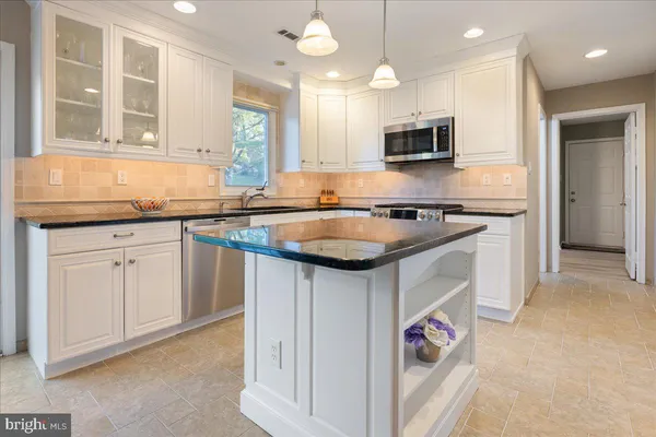 a kitchen with granite countertop a sink and cabinets