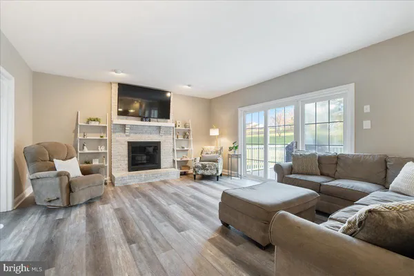 a living room with furniture fireplace and a large window