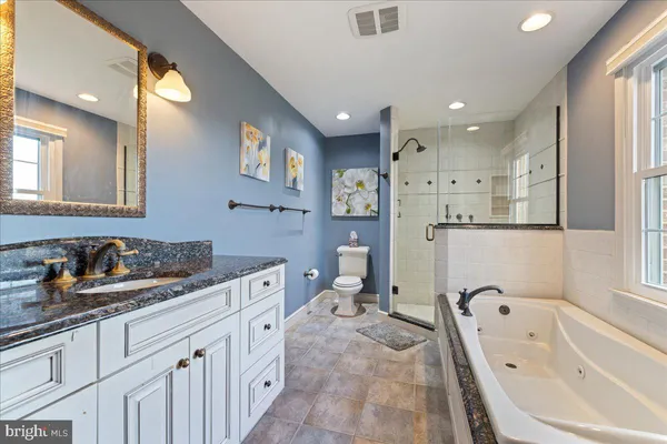 a spacious bathroom with a tub sink and mirror