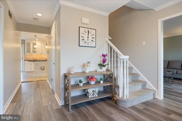 a hallway with wooden floor and white walls