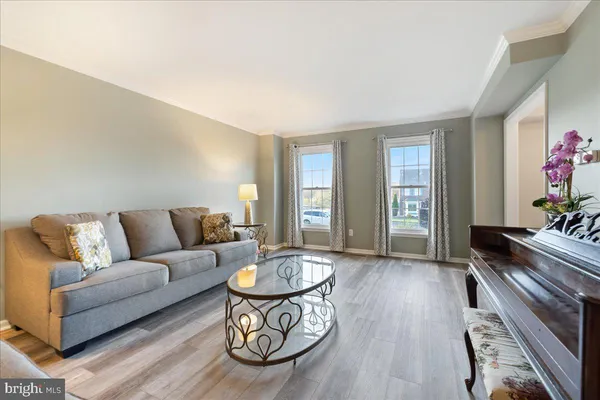 a living room with furniture and a dining table with wooden floor