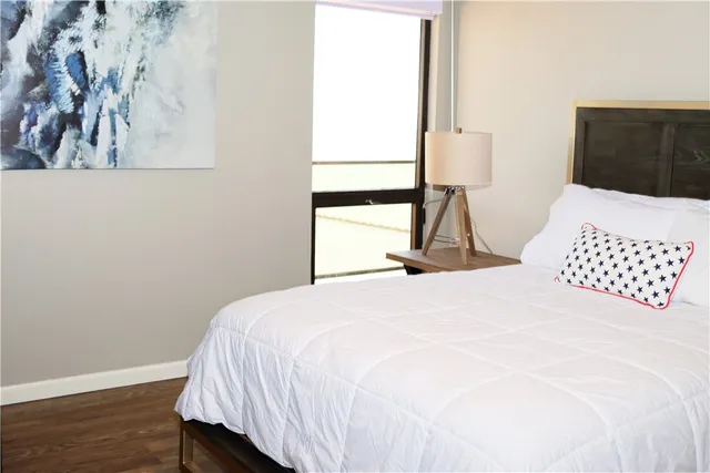 a bedroom with a bed and wooden floor