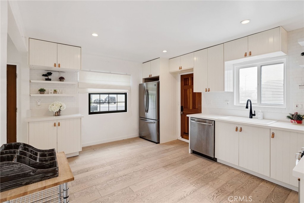 207 South Aviation Boulevard Manhattan Beach, CA 90266 - Photo 12 of 29 a large white kitchen with a refrigerator a sink a stove and cabinets