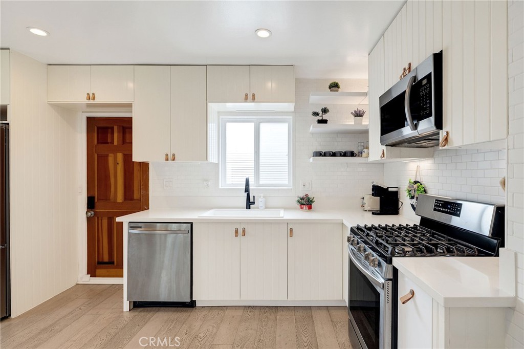 207 South Aviation Boulevard Manhattan Beach, CA 90266 - Photo 13 of 29 a kitchen with stainless steel appliances a stove microwave and sink