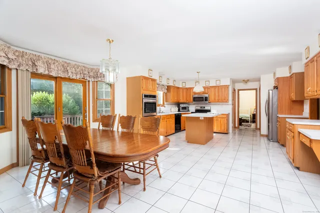 a kitchen with stainless steel appliances kitchen island granite countertop a table and chairs