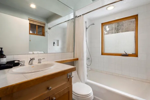 a bathroom with a sink a mirror a toilet and bathtub
