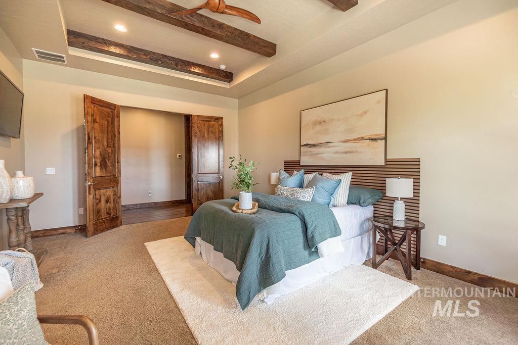 15350 Syrah Court Caldwell, ID 83607 - Photo 28 of 50 Recessed tray ceiling with dark wood-finish beams and a ceiling fan
