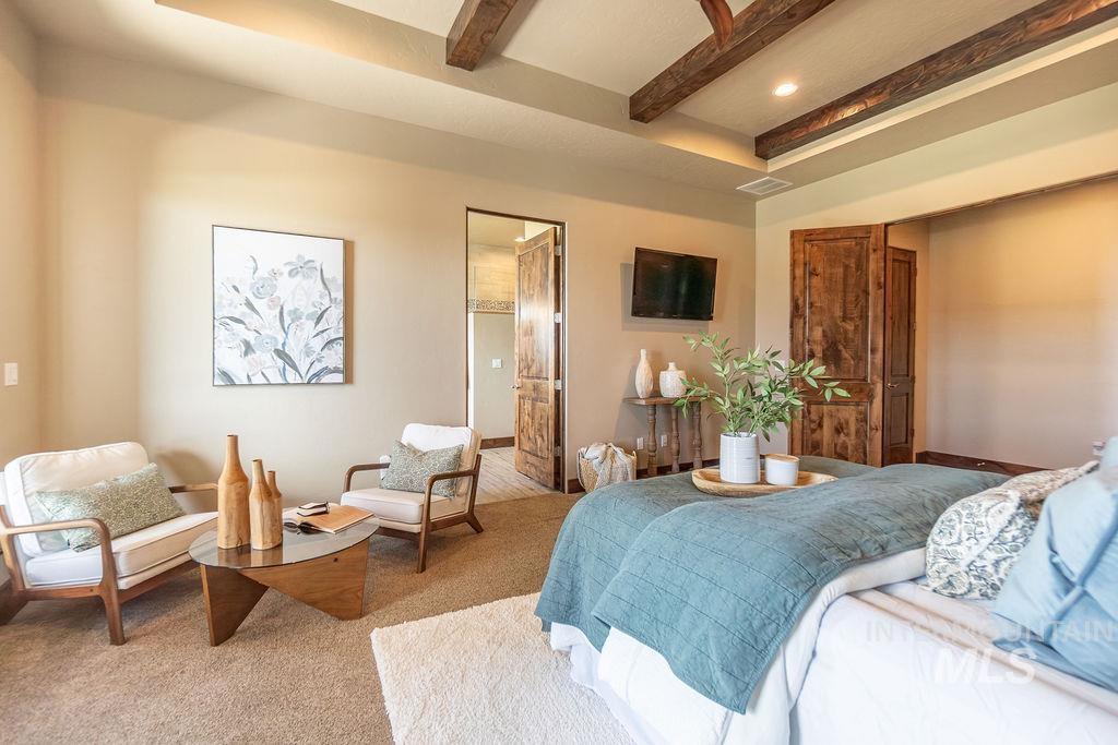 15350 Syrah Court Caldwell, ID 83607 - Photo 29 of 50 Spacious room featuring a tray ceiling with exposed wood beams, soft neutral wall tones, and plush carpet flooring