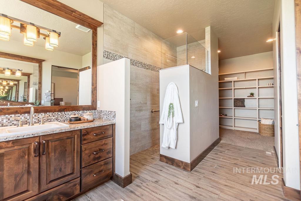 15350 Syrah Court Caldwell, ID 83607 - Photo 37 of 50 Bathroom featuring a wood-finish vanity with a double sink and granite countertop