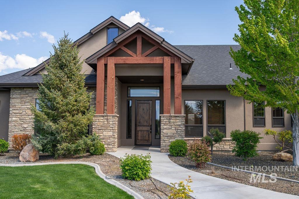 15350 Syrah Court Caldwell, ID 83607 - Photo 4 of 50 Exterior featuring a prominent wood beam entry, stone veneer accents, stucco siding, and a dark shingle roof