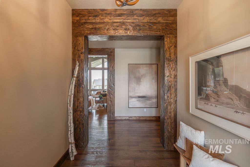 15350 Syrah Court Caldwell, ID 83607 - Photo 5 of 50 Archway featuring exposed wood-finish beams and trim, wood-finish flooring, and light-toned wall paint