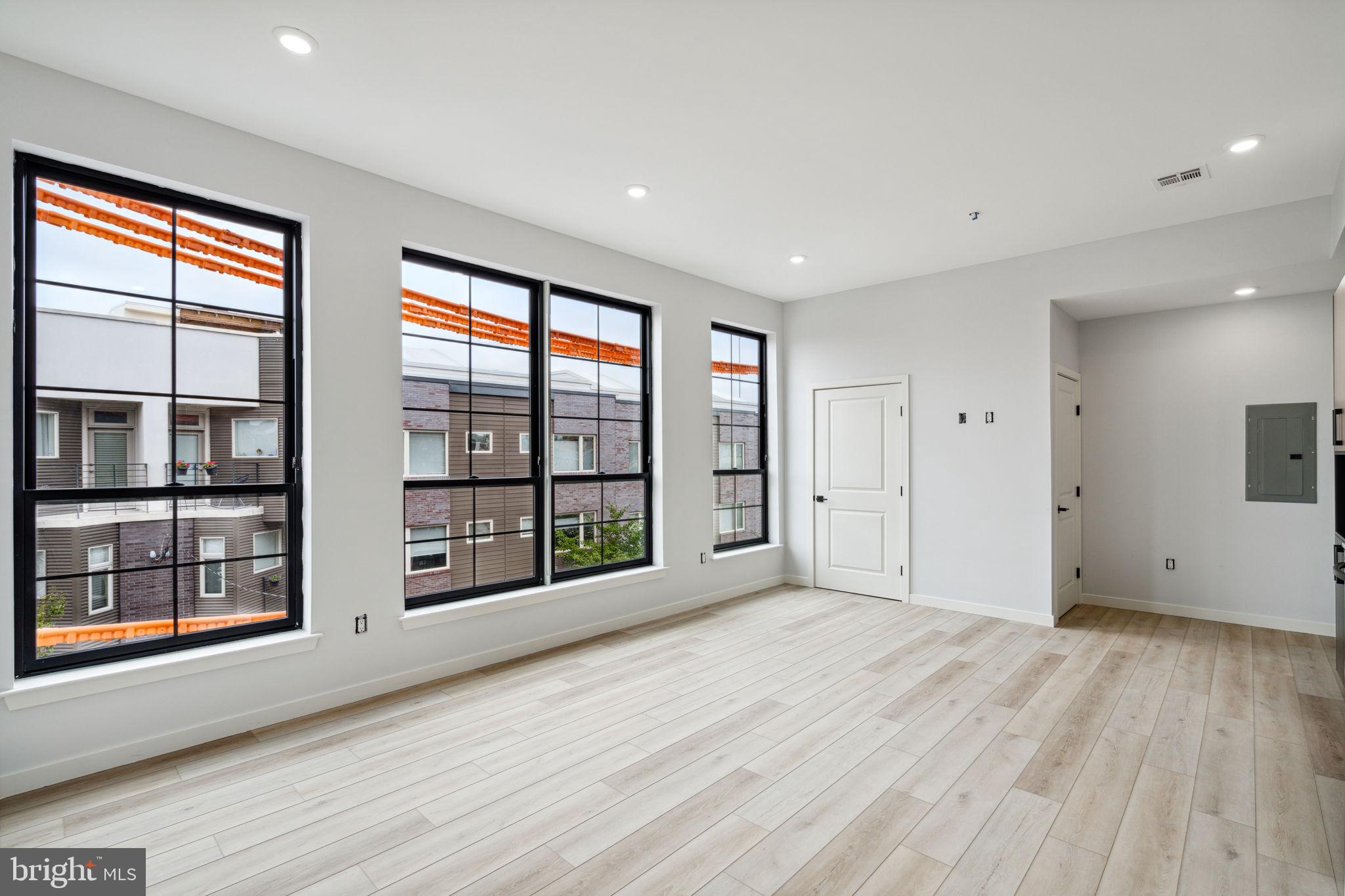 1112-16 East Berks Street, Unit 408 Philadelphia, PA 19125 - Photo 6 of 9 a view of an empty room with a window and wooden floor