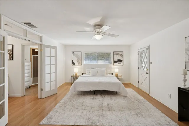 a bedroom with a large bed and a chandelier