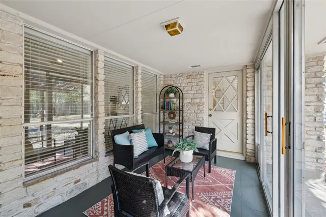 a living room with furniture and a floor to ceiling window
