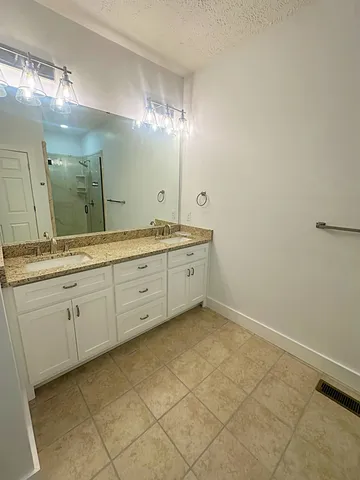 a spacious bathroom with a granite countertop sink a mirror and a