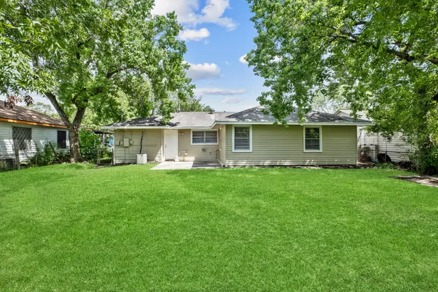a view of a house with backyard and a tree