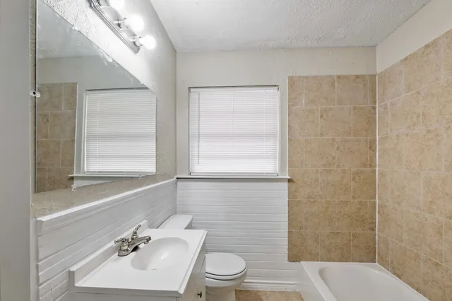 a bathroom with a sink toilet a mirror and shower