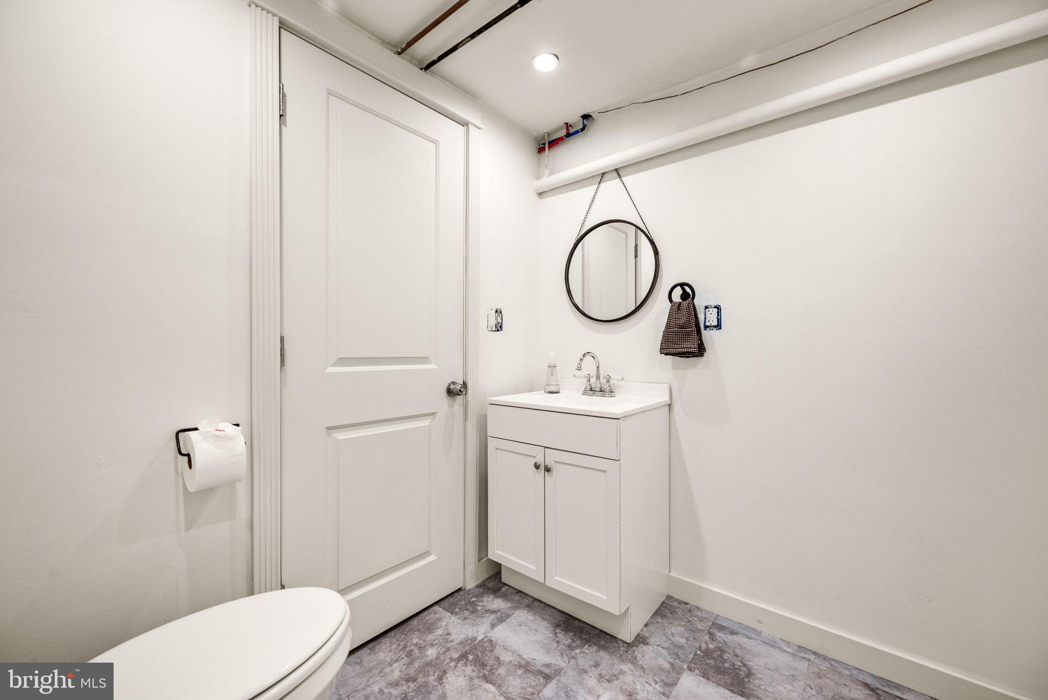 3310 West Penn Street Philadelphia, PA 19129 - Photo 26 of 26 a bathroom with a toilet sink and mirror