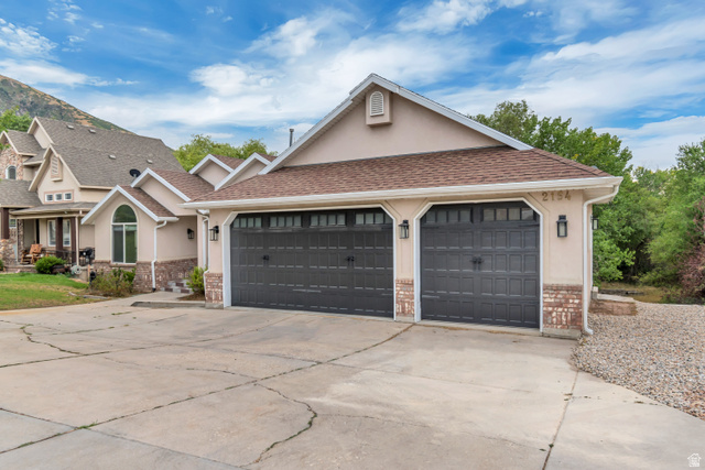 2154 Wasatch Boulevard Sandy, UT 84092 - Photo 29 of 55 View of front facade with driveway, stucco siding, an attached garage, and roof with shingles