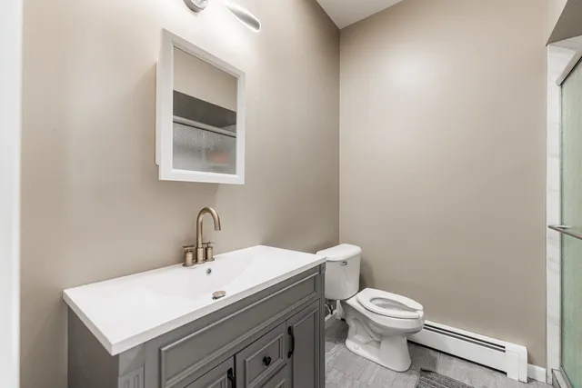 a bathroom with a toilet a sink and mirror