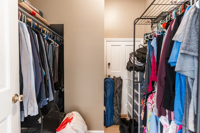 a view of walk in closet with clothes and shoes