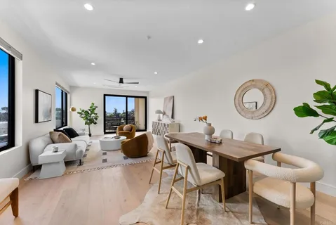 a living room with furniture a clock and a large window