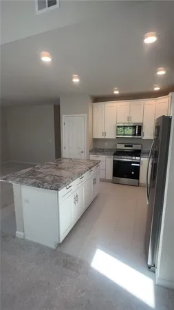 a kitchen with stainless steel appliances granite countertop a refrigerator and a stove