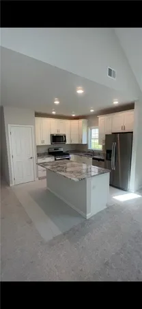 a large white kitchen with stainless steel appliances