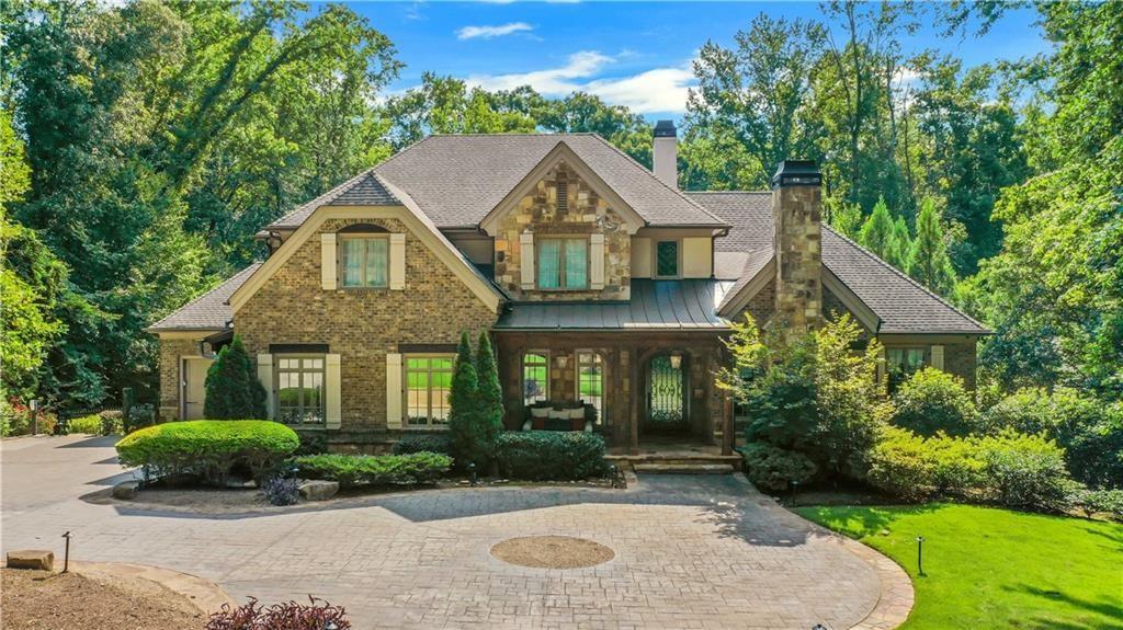 5265 Peachtree Dunwoody Road Sandy Springs, GA 30342 - Photo 116 of 122 a front view of a house with a yard and garage