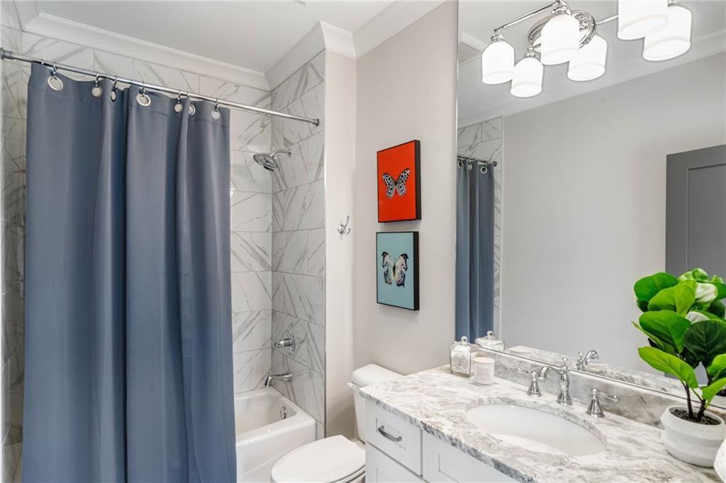 5265 Peachtree Dunwoody Road Sandy Springs, GA 30342 - Photo 57 of 122 a bathroom with a granite countertop sink a toilet and shower