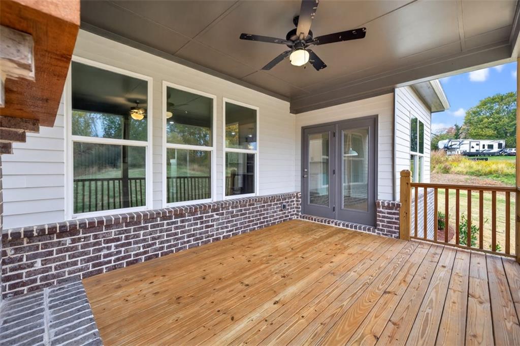 8845 Jot Em Down Road Gainesville, GA 30506 - Photo 67 of 87 a view of a balcony with a ceiling fan and wooden floor